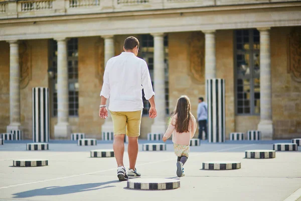 Happy family of two on a street of Paris. Father with his adorable 4 year old daughter