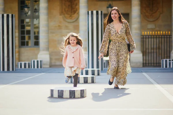 Happy family of two on a street of Paris. Mother with her adorable 4 year old daughter