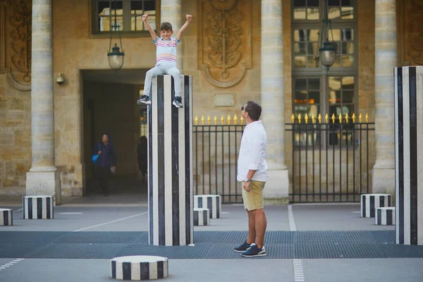 Happy family of two on a street of Paris. Father with his 8 year old son in Palais Royal in Paris, France