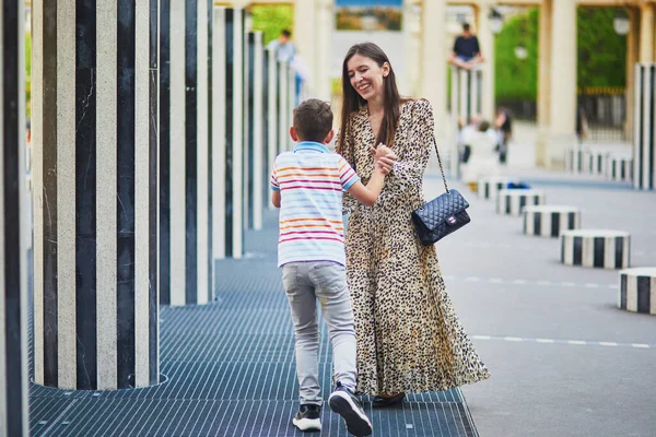 Happy family of two on a street of Paris. Mother with her 8 year son in Palais Royal