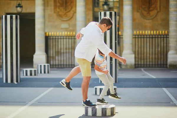 Happy family of two on a street of Paris. Father with his 8 year old son in Palais Royal in Paris, France