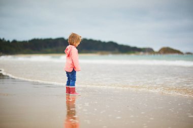 Brittany, Fransa 'nın Atlantik kıyısındaki kumsalda küçük sevimli bir kız. Küçük çocuk deniz ya da okyanus kenarında tatilin tadını çıkarıyor. Çocuklarla seyahat etmek.