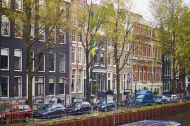 AMSTERDAM, THE NETHERLANDS - MAY 1, 2022: Ukrainian flag as sign of support of Ukraine by Dutch Government on a building in Amsterdam, the Netherlands