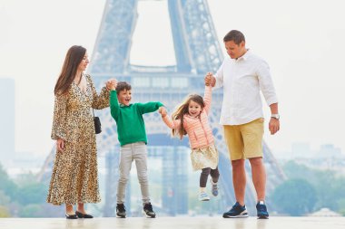 Dört kişilik mutlu bir aile Paris, Fransa seyahatinin tadını çıkarıyor. Anne, baba, oğul ve kız Paris 'teki Eyfel Kulesi yakınlarında. Evli ve çocuklu çift Fransa 'ya seyahat ediyor.