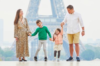 Dört kişilik mutlu bir aile Paris, Fransa seyahatinin tadını çıkarıyor. Anne, baba, oğul ve kız Paris 'teki Eyfel Kulesi yakınlarında. Evli ve çocuklu çift Fransa 'ya seyahat ediyor.