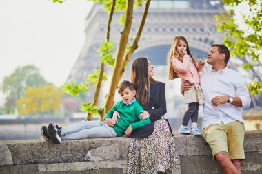Dört kişilik mutlu bir aile Paris, Fransa seyahatinin tadını çıkarıyor. Anne, baba, oğul ve kız Paris 'teki Eyfel Kulesi yakınlarında. Evli ve çocuklu çift Fransa 'ya seyahat ediyor.