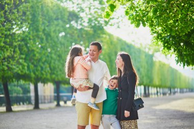 Dört kişilik mutlu bir aile Paris, Fransa seyahatinin tadını çıkarıyor. Anne, baba, oğul ve kız Paris 'teki Tuileries bahçesinde. Evli ve çocuklu çift Fransa 'ya seyahat ediyor.