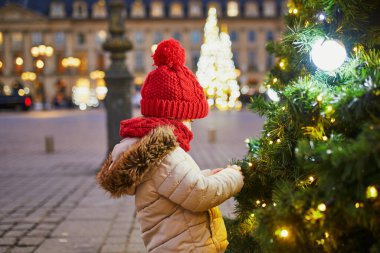 Paris, Fransa 'da Noel pazarında kırmızı şapkalı neşeli anaokulu kızı.
