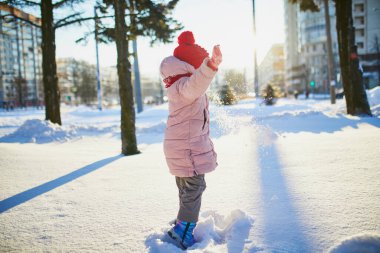 Güzel kış parkında buz gibi bir kış gününde eğlenen sevimli anaokulu kızı. Karda oynayan sevimli bir çocuk. Çocuklu aileler için kış etkinlikleri