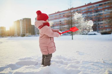 Güzel kış parkında buz gibi bir kış gününde eğlenen sevimli anaokulu kızı. Karda oynayan sevimli bir çocuk. Çocuklu aileler için kış etkinlikleri