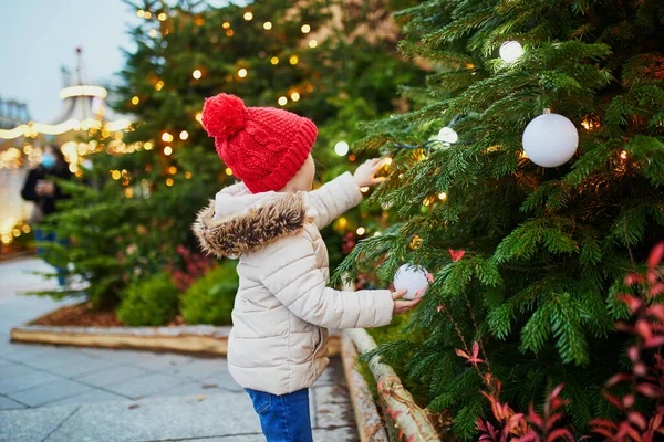 幸せな陽気な就学前の女の子で赤い帽子でクリスマスマーケットでパリ フランス — ストック写真