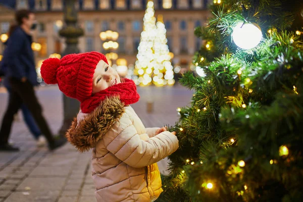 幸せな陽気な就学前の女の子で赤い帽子でクリスマスマーケットでパリ フランス — ストック写真