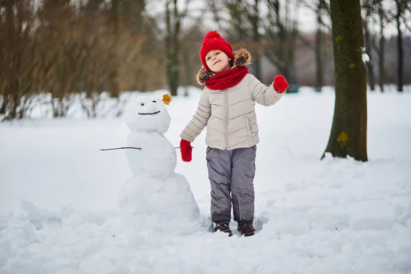 豪雪の日に雪だるまを作る愛らしい女子高生 雪と遊ぶ幸せな子供 子供のための冬の活動 — ストック写真