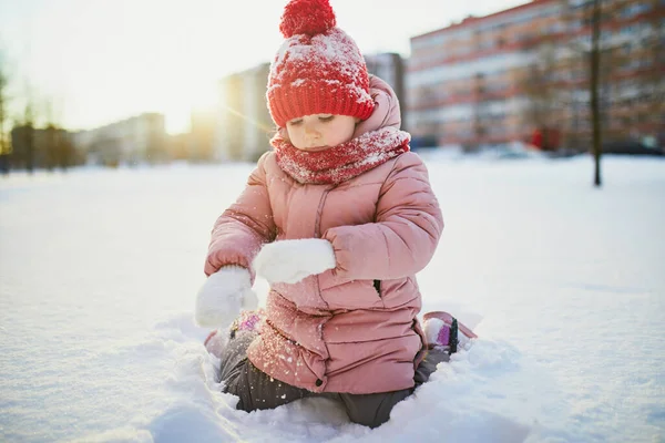 雪の寒い冬の日に美しい冬の公園で楽しんでいる愛らしい未就学児の女の子 雪の中で遊ぶかわいい子供 子供連れの家族のための冬の活動 — ストック写真