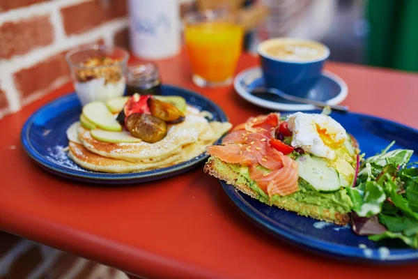 Avokado ve somonlu tost, haşlanmış yumurta, meyveli krep ve akçaağaç şurubu ve Fransa 'nın Kafesi' nde düz beyaz kahve ile nefis sağlıklı bir kahvaltı.