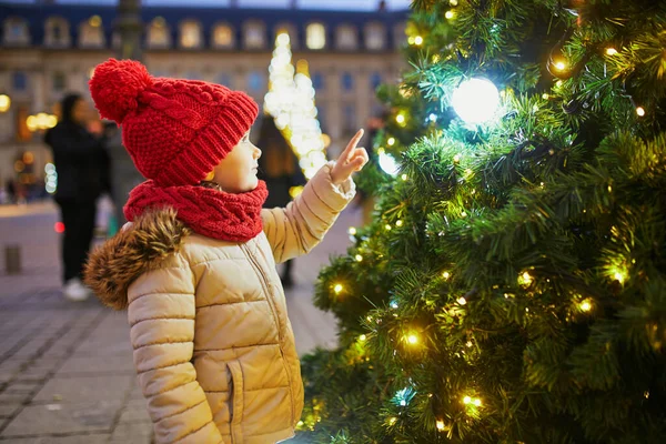 幸せな陽気な就学前の女の子で赤い帽子でクリスマスマーケットでパリ フランス — ストック写真