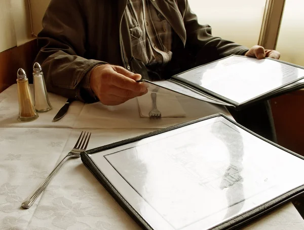 Mann hält Speisekarte in der Hand. — Stockbild In der Gaststätte. — Stockfoto