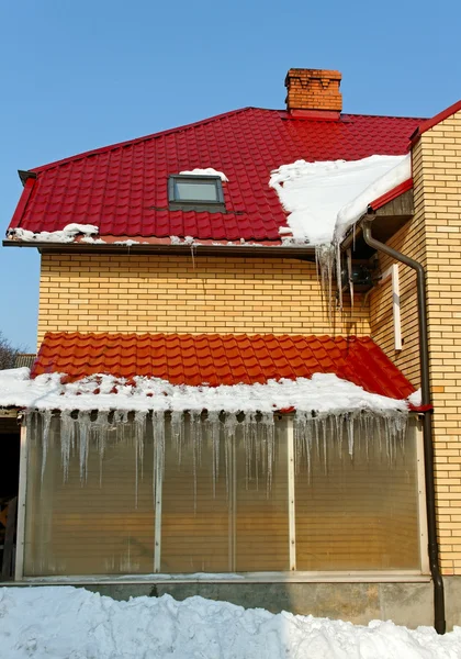 Icicles on the edge of a brick house. — Stock Photo, Image