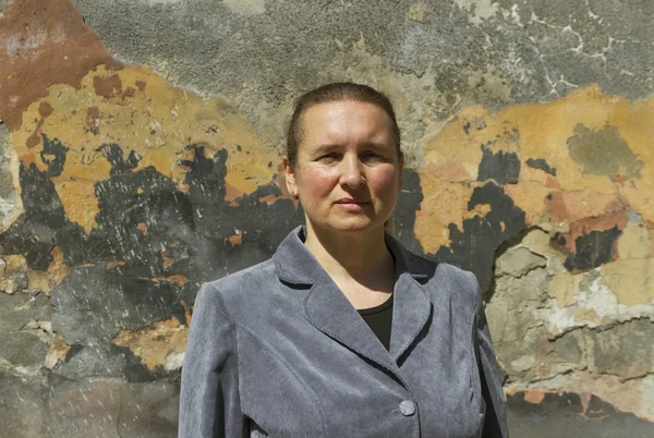 Vrouw op straat naast de muur. — Stockfoto