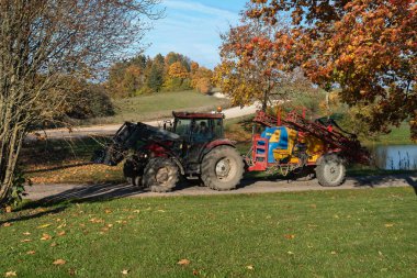 Büyük bir traktörle kırsal manzara.