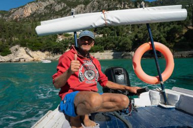 GREECE, KORFU - 24 Eylül: Corfu (veya Kerkyra) Yunan adasıdır. İyon Denizi 'nde. Paleokastrica 'daki turizm gemisi kaptanının 23 Eylül 2021' deki görüntüsü, Paleokastrica, Korfu, Yunanistan