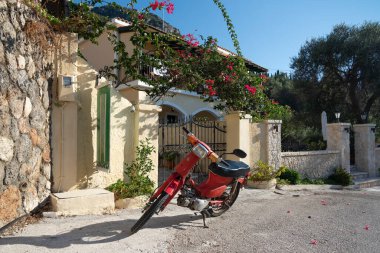 Yunanistan 'da kapalı bir evin kapısında kırmızı motosiklet.