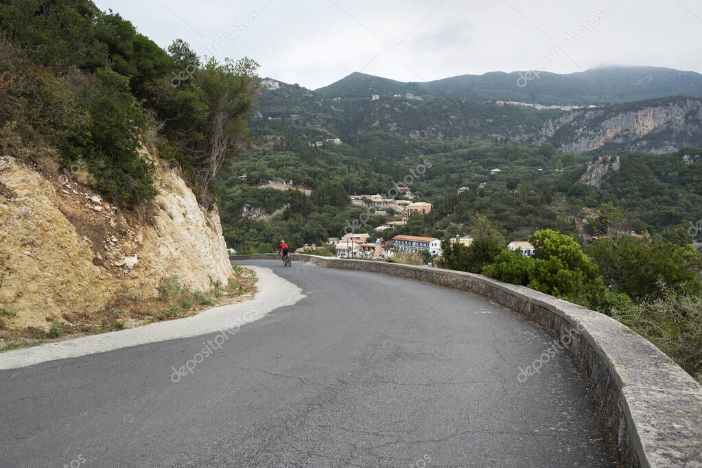 View of a mountain road with a cyclist in Greece.