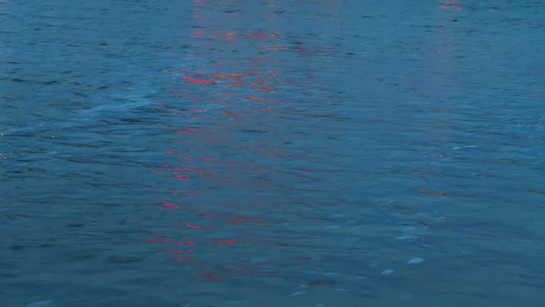 Отражение Красного Света Голубой Поверхности Воды — стоковое фото
