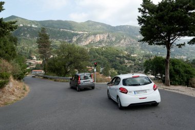 GREECE, KORFU-19 Eylül: Korfu Yunan adasıdır. 19 Eylül 2021 'de Paleokastrica, Paleokastrica, Korfu, Yunanistan' daki tepede trafik ışığı ve arabalı bir dağ yolu görülüyor..