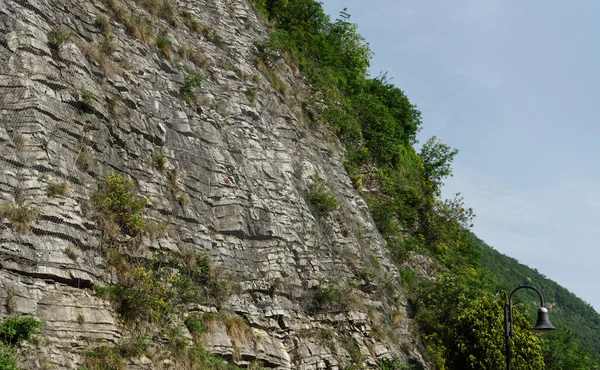 イタリアの山道に金属メッシュを持つ石の壁の断片 — ストック写真