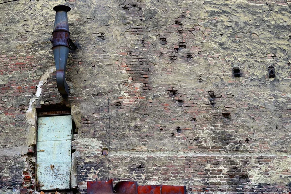 Backsteinalte Mauer mit einem Riss und einem Rohr — Stockfoto