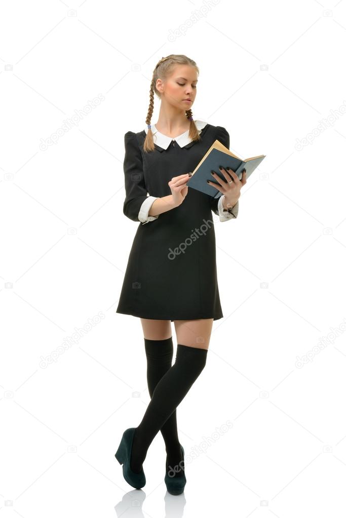 Beautiful girl student in a black dress is reading a book