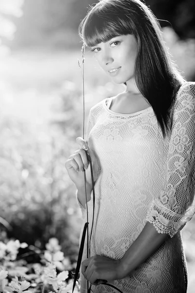 Vacker flicka i vit kort klänning står med kottar i händer — Stockfoto