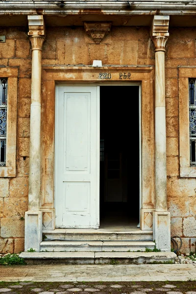 Grungy puerta vieja de una vieja casa de piedra con columnas — Foto de Stock