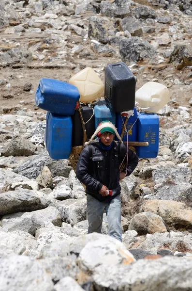 El portero Sherpa lleva carga pesada en el Himalaya en el Everest Base Camp trek, Nepal, Himalaya — Foto de Stock