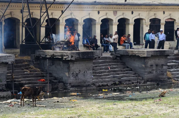 Persone che fanno cerimonia di cremazione lungo il sacro fiume Bagmati al Tempio di Pashupatinath, Kathmandu — Foto Stock