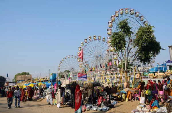 Persone che visitano il mercato locale vicino al parco divertimenti durante la tradizionale fiera del bestiame a Pushkar, India — Foto Stock