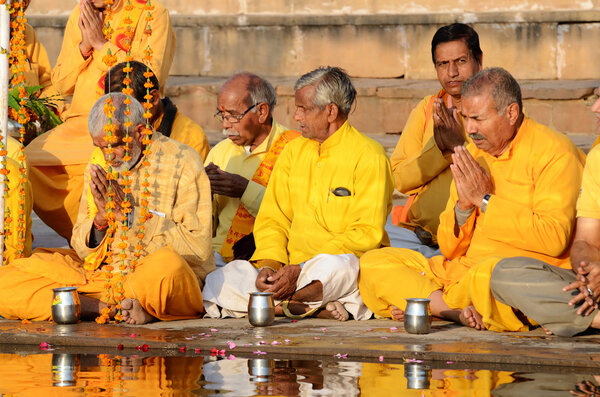 Senior men perform puja - ritual ceremony at holy Pushkar Sarovar lake,India
