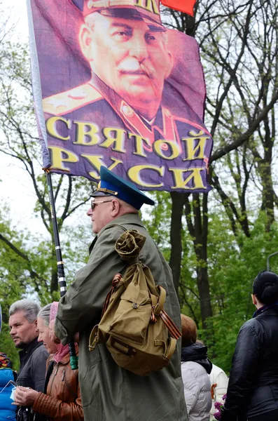 Мужчина держит флаг с портретом лидера Советского Союза Иосифа Сталина во время торжественного парада на Аллее Славы, посвященного 69-й годовщине победы во Второй мировой войне 1941-1945 годов в Одессе, Украина — стоковое фото
