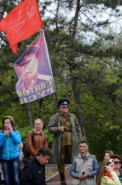 :L'uomo tiene la bandiera con il ritratto di Joseph Stalin, leader dell'Unione Sovietica, durante la celebrazione del giorno della vittoria il 9 maggio 2014 a Odessa, Ucraina — Foto Stock