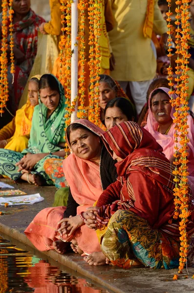Ienior women perform puja - ritual ceremony at holy Pushkar Sarovar lake, India — стоковое фото