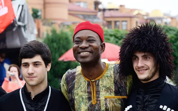 African and Georgian men in traditional clothes preparing to performance at Day of Kiev holiday — Stock Photo, Image