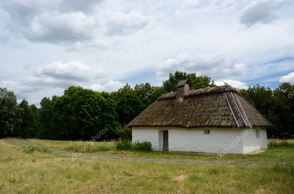 Antique white clay house with hay roof in Pirogovo park, Kiev
