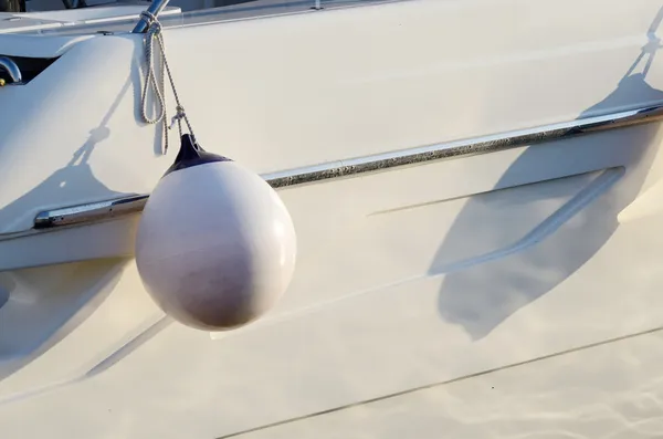 Garde-boue rond blanc pour bateau à moteur.Il est utilisé comme pare-chocs pour absorber l'énergie cinétique d'un bateau ou d'un navire accostant contre une jetée — Photo