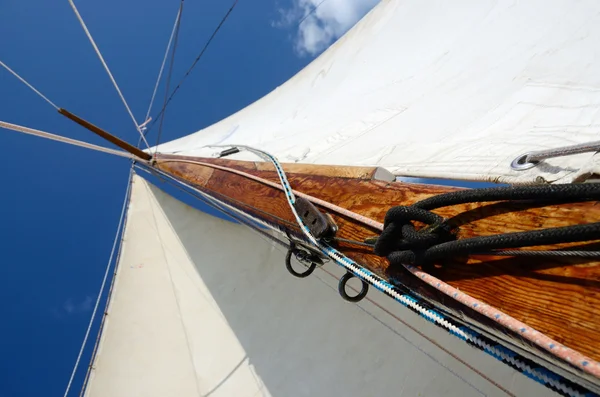 Old wooden mast with crosspieces, backstays,mainsail and staysail, view from deck of boat — Stock Photo, Image