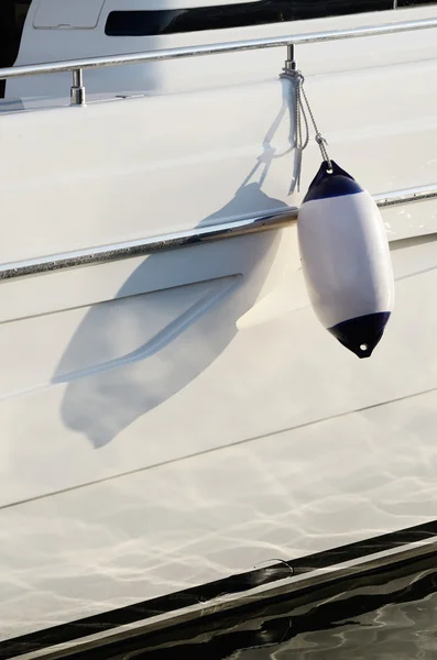 白色摩托船挡泥板，为保护一艘帆船的一侧，当它向插入端口的设备 — 图库照片