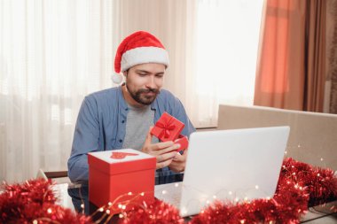 Noel zamanı evde oturan kırmızı bardaklı hippi adam..