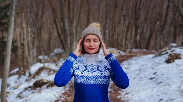 Vacker kvinna som står bland träd i vinterskogen — Stockfoto