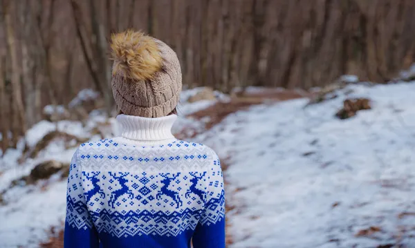 Vacker kvinna som står bland träd i vinterskogen — Stockfoto