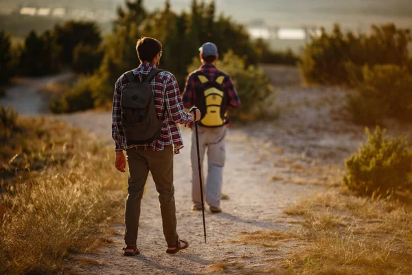 Dos hombres excursionistas disfrutan de un paseo en la naturaleza, la hora del atardecer en verano — Foto de Stock